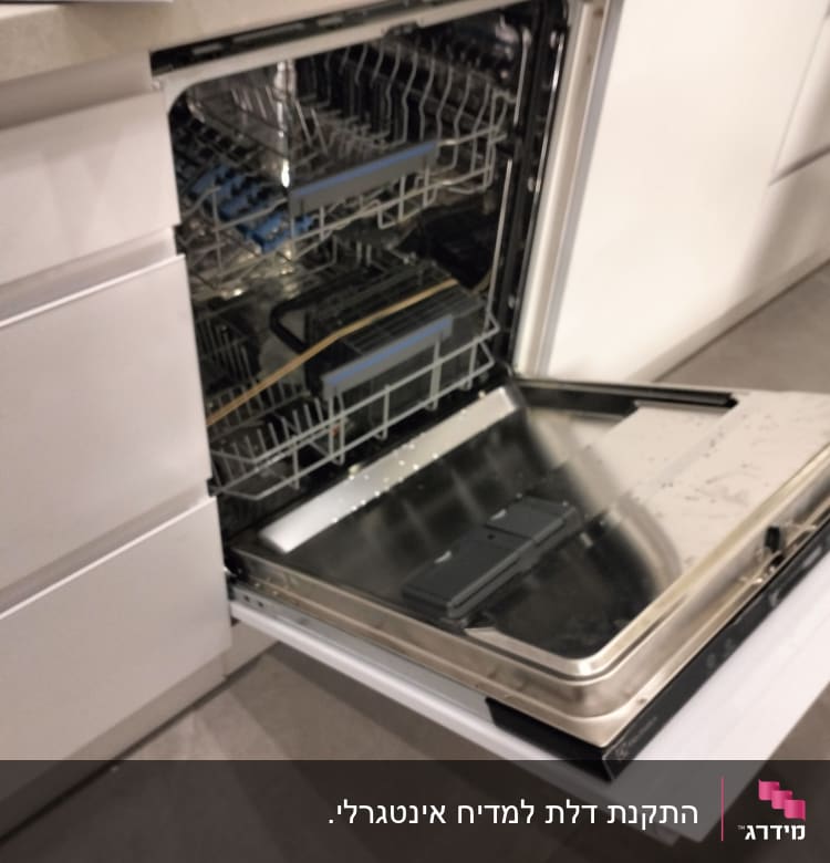 מדיח כלים פתוח עם מדפים ריקים במטבח מודרני